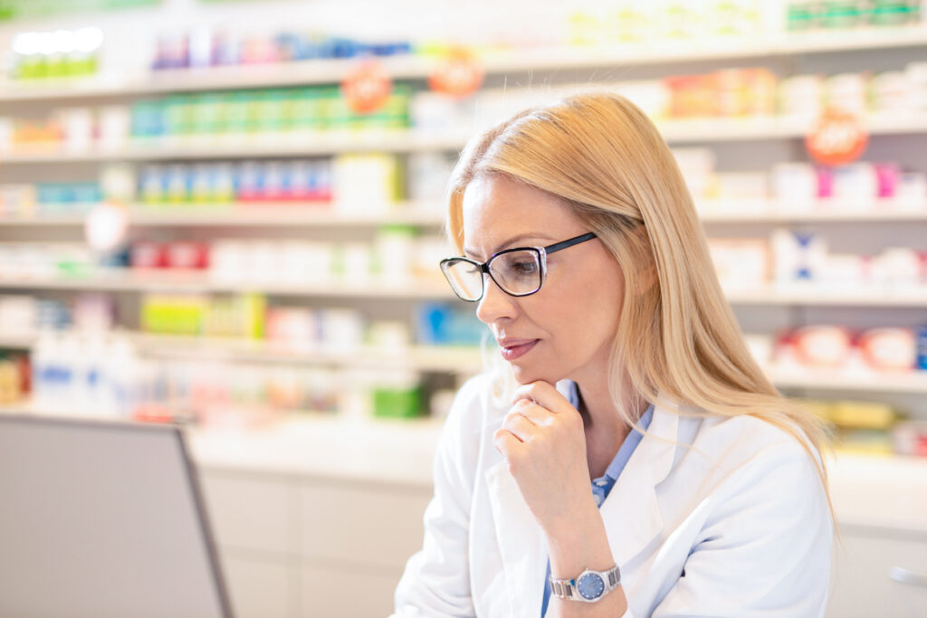 Pharmacist using computer at Pharmacy.